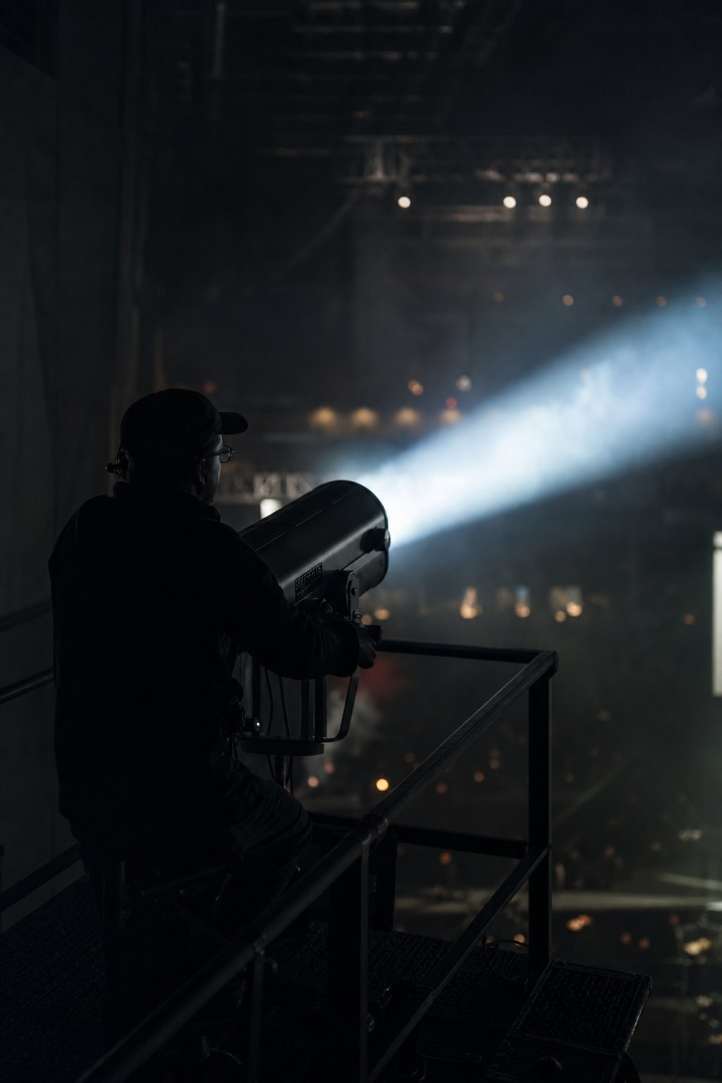 Technika sceniczna Bytom - operator naświetlacza wysoko na podeście kierujący wiązką przez mgłę
